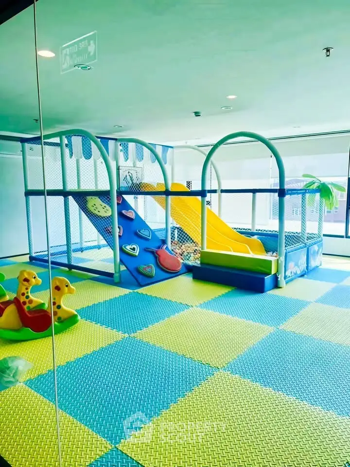 Vibrant indoor children's play area with slides and colorful flooring in modern building.