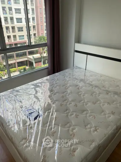 Modern bedroom with new mattress and large window view in urban apartment