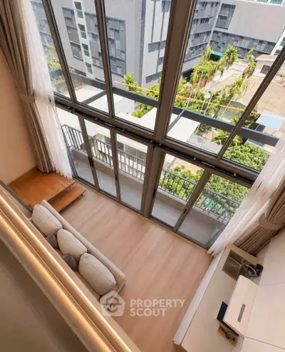 Stunning high-ceiling living room with floor-to-ceiling windows and balcony view.