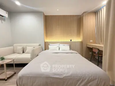 Modern bedroom with cozy bed, stylish sofa, and elegant lighting in a chic apartment.