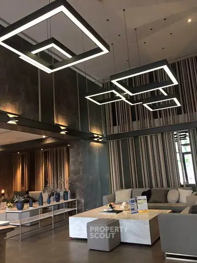 Luxurious modern living room with stylish geometric lighting and elegant decor.