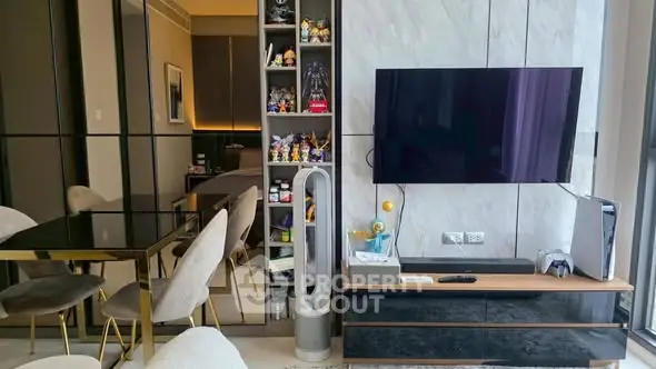 Modern living room with sleek furniture and entertainment setup, featuring a stylish dining area and contemporary decor.