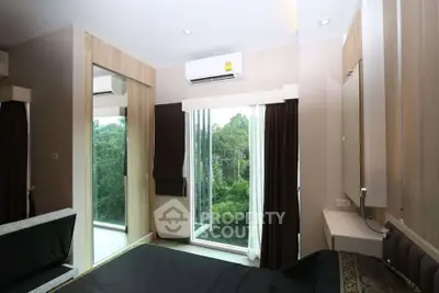 Modern bedroom with large windows and lush green view, featuring air conditioning and sleek design.