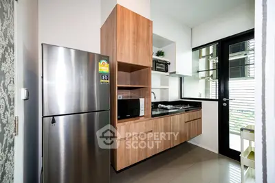 Modern kitchen with sleek appliances and stylish cabinetry in a contemporary apartment.