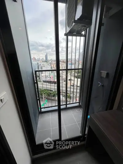 Modern apartment balcony with city view and sleek glass doors