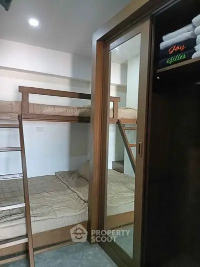 Cozy bedroom with bunk beds and mirrored wardrobe, perfect for maximizing space in modern living.