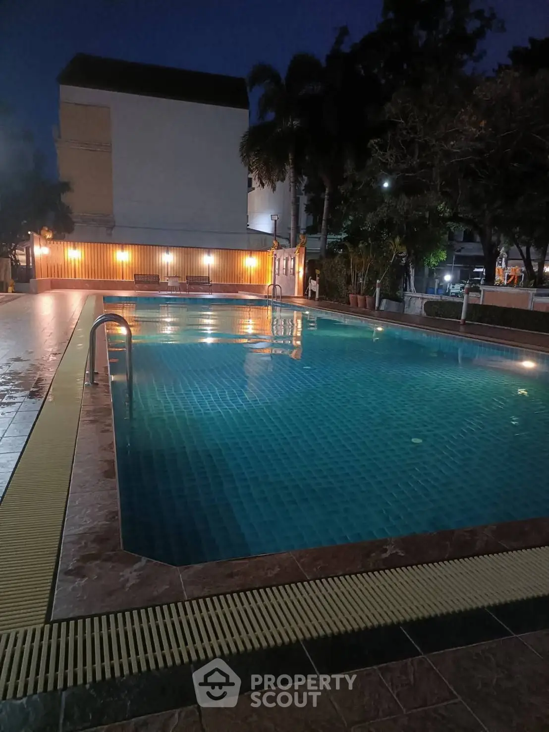 Stunning evening view of a serene swimming pool in a residential complex.