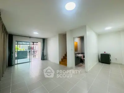 Spacious modern living room with tiled flooring and balcony access