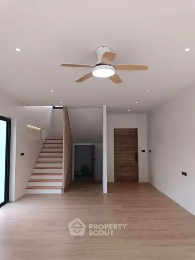 Spacious modern living room with wooden flooring and ceiling fan