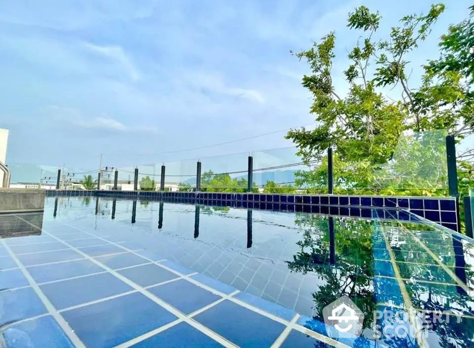 Stunning rooftop pool with glass railing and city views