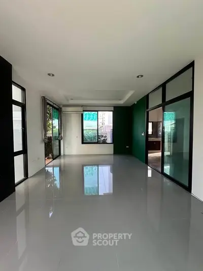 Spacious modern living room with large windows and glossy tiled floor