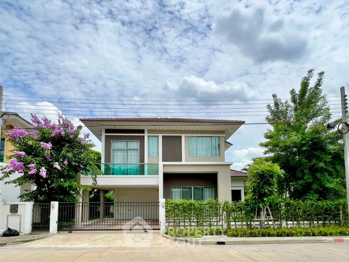 Stunning modern two-story house with lush greenery and spacious driveway.