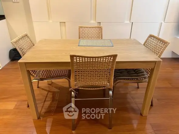 Modern dining area with wooden table and stylish chairs on polished floor.