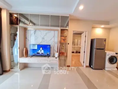 Modern living room with built-in TV unit, sleek appliances, and elegant flooring.
