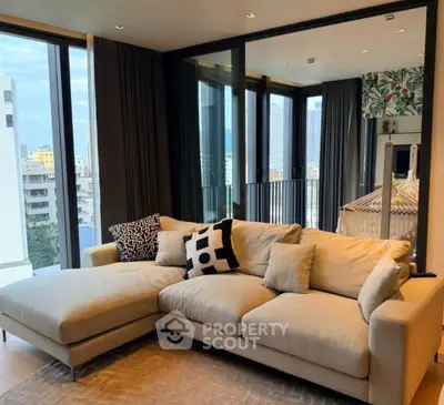 Stylish living room with modern beige sectional sofa and city view balcony.