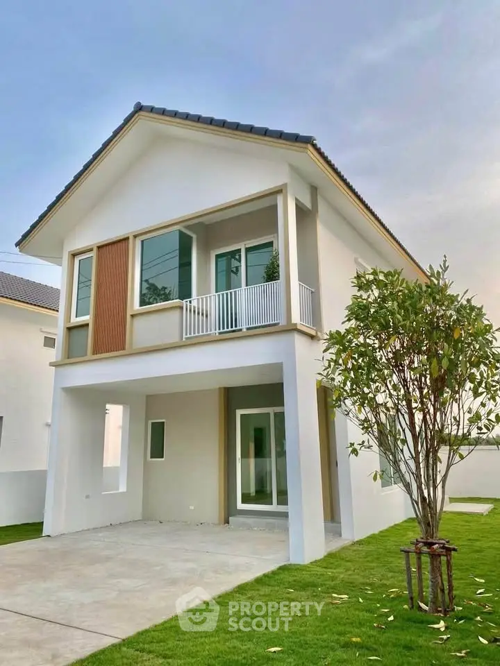 Modern two-story house with large windows and a well-maintained lawn