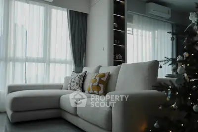 Modern living room with cozy sectional sofa and Christmas tree by large windows