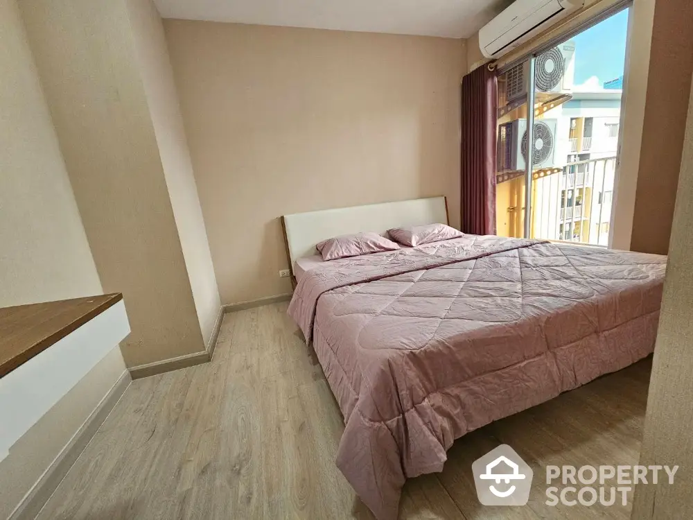 Cozy bedroom with large bed and natural light from balcony