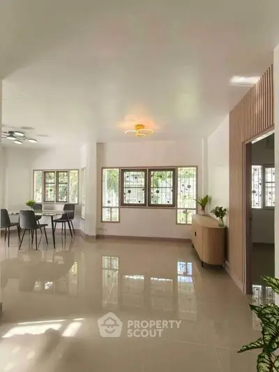 Spacious modern living room with elegant dining area and large windows for natural light.