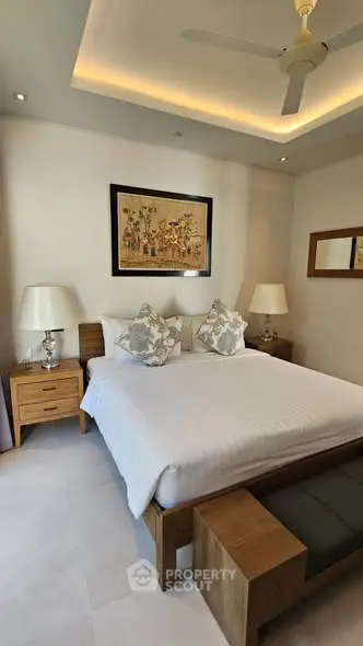 Elegant bedroom with modern decor, featuring a cozy bed, stylish lamps, and tasteful artwork, perfect for relaxation.