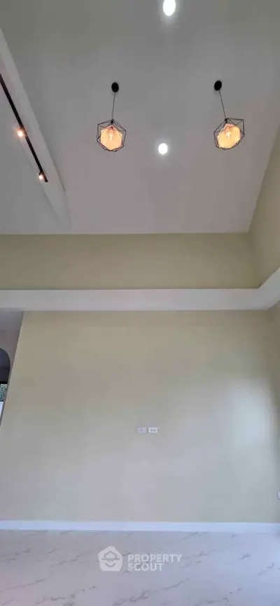 Spacious interior with high ceiling and modern lighting fixtures.