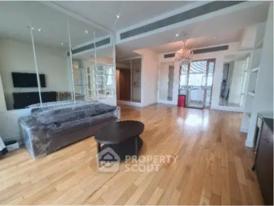 Spacious living room with hardwood floors and elegant chandelier