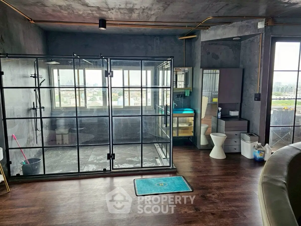 Modern industrial-style bathroom with glass shower and city view