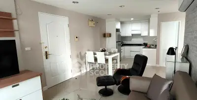 Modern open-layout living room and kitchen with sleek furniture and neutral tones.