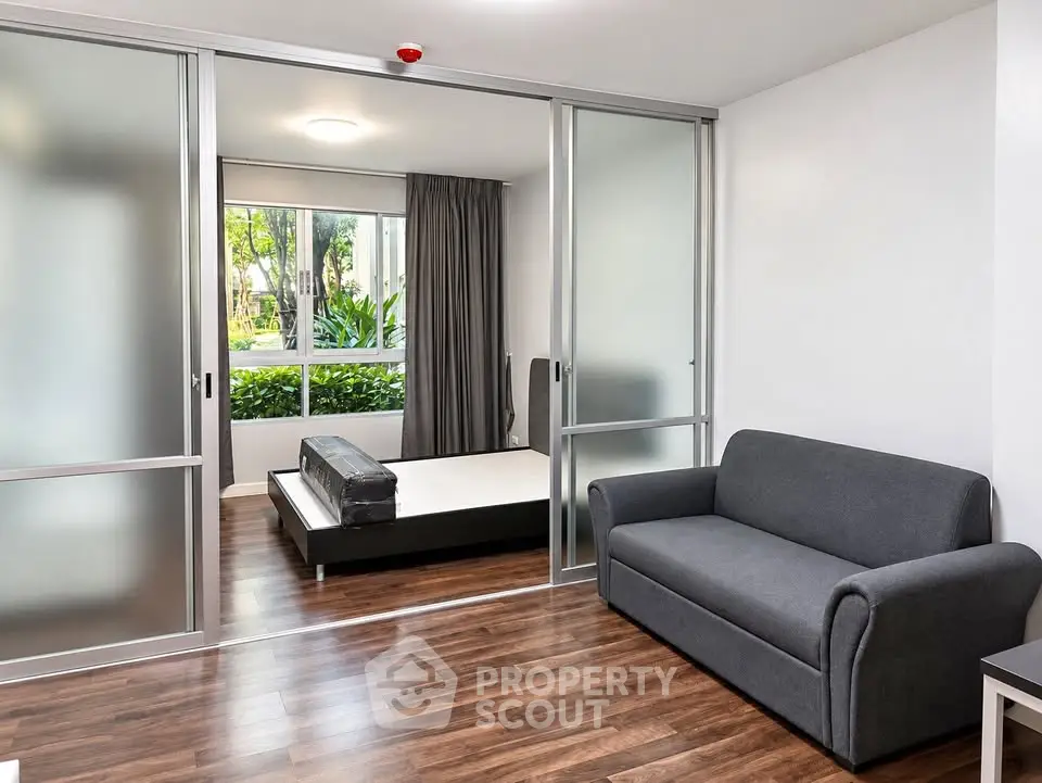 Modern studio apartment with sliding glass doors and garden view