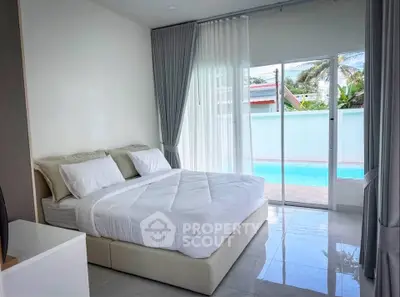 Luxurious bedroom with pool view and elegant decor in modern real estate property.