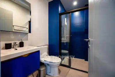 Modern bathroom with blue accents and glass shower enclosure