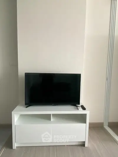 Modern living room with sleek TV stand and flat-screen TV, perfect for entertainment.