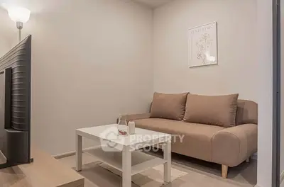 Cozy living room with modern sofa and TV, perfect for relaxation.