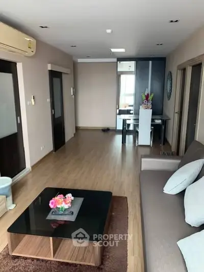Spacious living room with modern decor and dining area in open layout apartment.