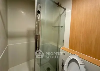 Modern bathroom with glass shower and wooden accents