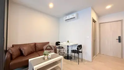 Modern living room with brown sofa, air conditioning, and cozy dining area in a stylish apartment.