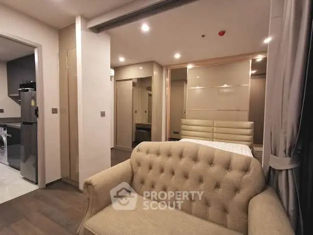 Modern apartment interior with cozy living area and sleek kitchen appliances.