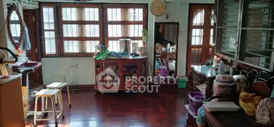 Spacious living room with wooden flooring and large windows, ideal for cozy gatherings.