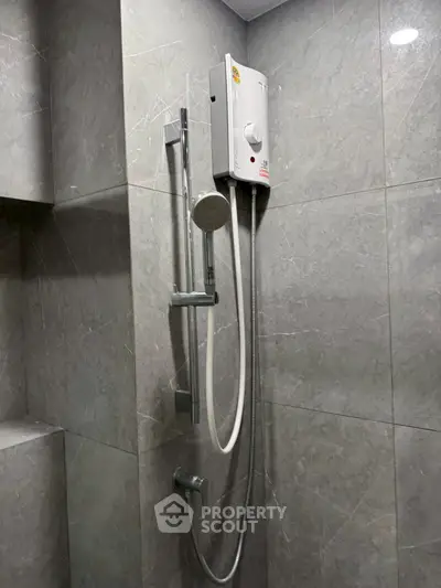 Modern bathroom with sleek shower and gray tiled walls