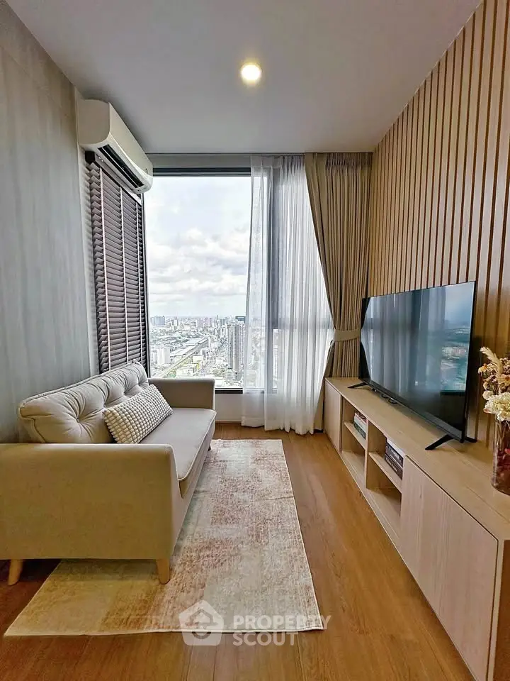 Modern living room with city view, featuring sleek furniture and large TV, perfect for urban living.