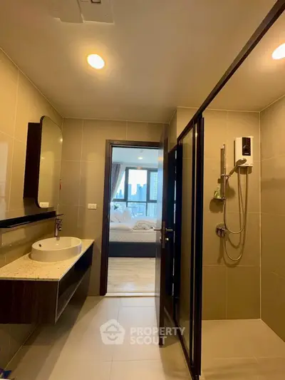 Modern bathroom with sleek design and city view from adjacent bedroom.