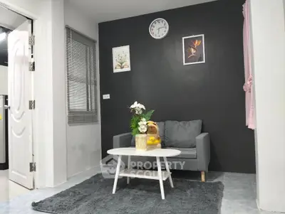 Cozy living room with modern decor, featuring a gray sofa, white coffee table, and stylish wall art.