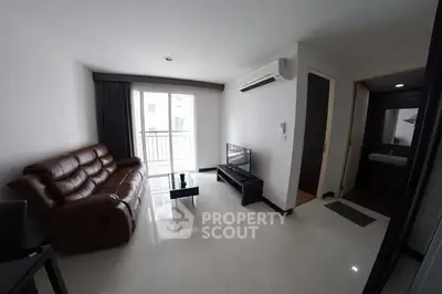 Modern living room with leather sofa and balcony access in a bright apartment.