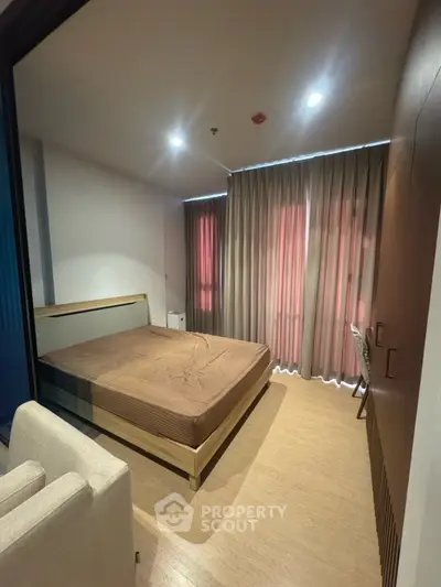 Cozy bedroom with modern furnishings and large window with curtains