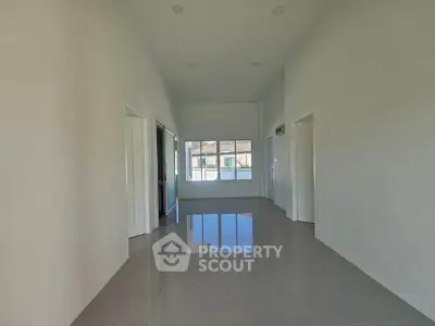 Spacious modern living room with high ceilings and large windows offering natural light.