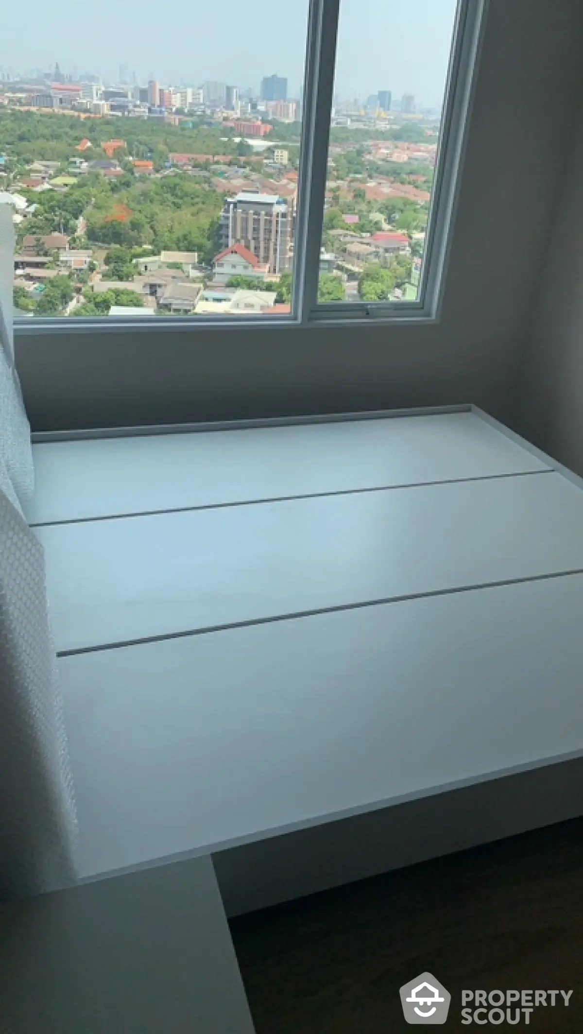 Modern bedroom with panoramic city view from high-rise window