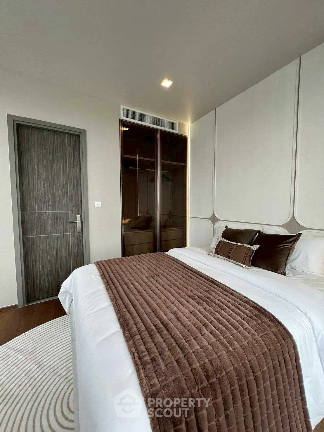 Luxurious bedroom with modern design and plush bedding in upscale apartment.