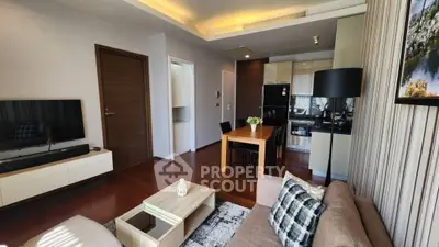 Modern living room with open kitchen, wooden flooring, and stylish decor