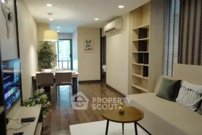 Modern living room with stylish decor and open dining area in a cozy apartment.