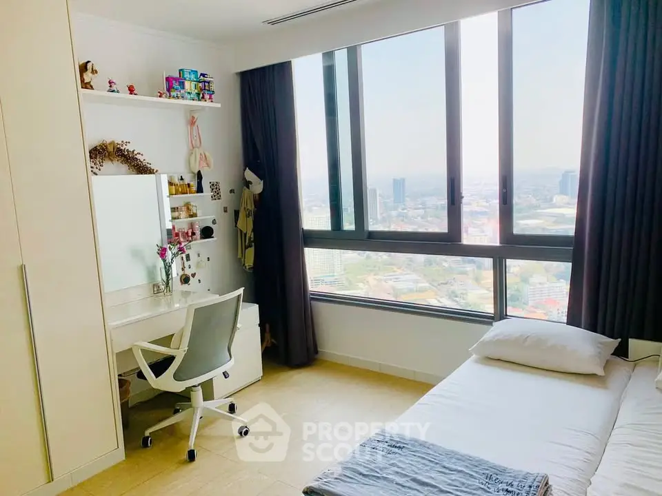 Bright bedroom with large window offering stunning city views, modern furniture, and cozy decor.
